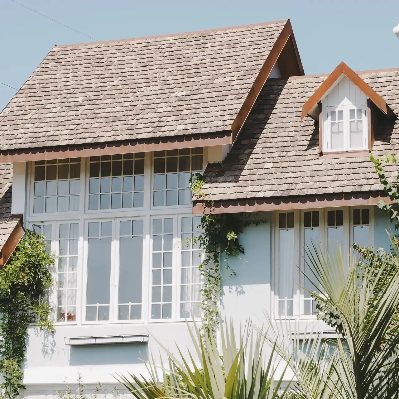An upscale Southwest Florida home with a fresh cedar-shake roof, framed by palms